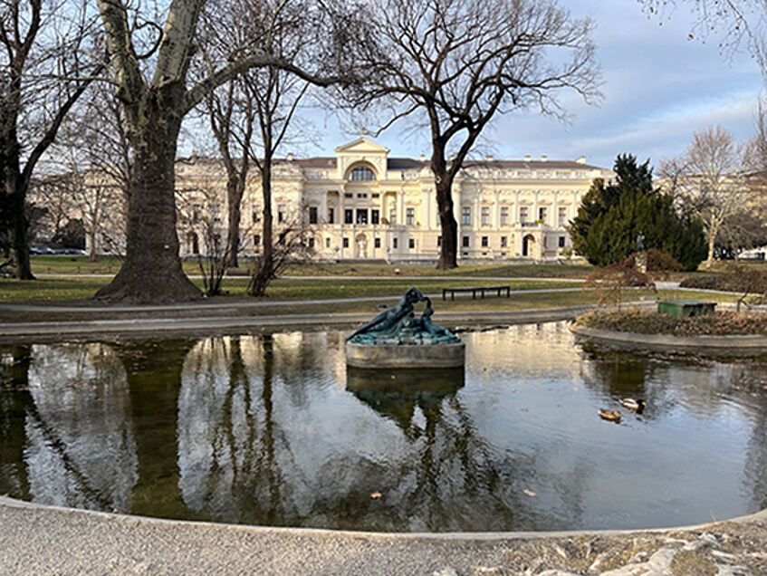 Park with pond and historic building in the background